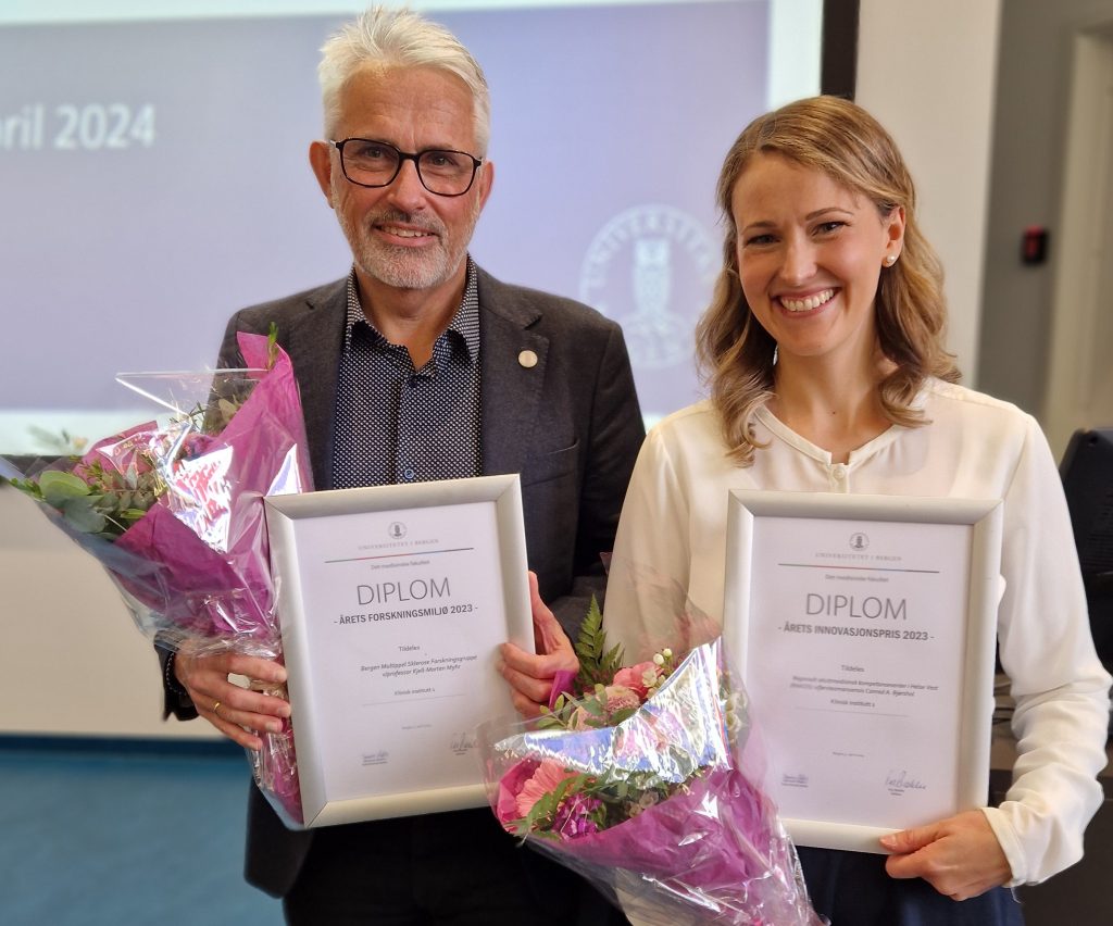 Bilde av de to stolte prisvinnern, med blomster og diplom. 